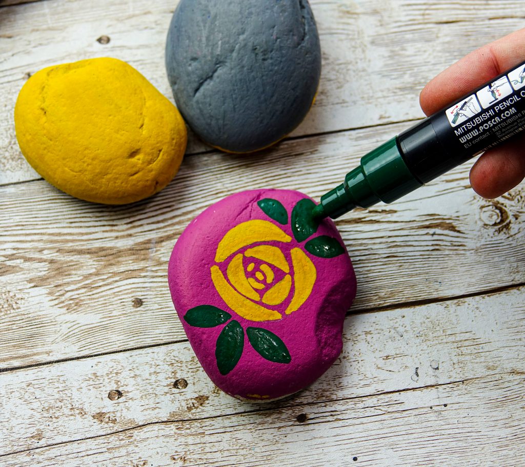 Decorate stones with flower designs