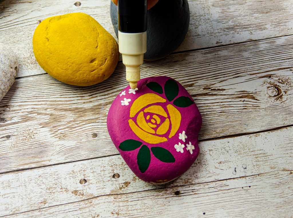Decorate stones with flower designs in POSCA